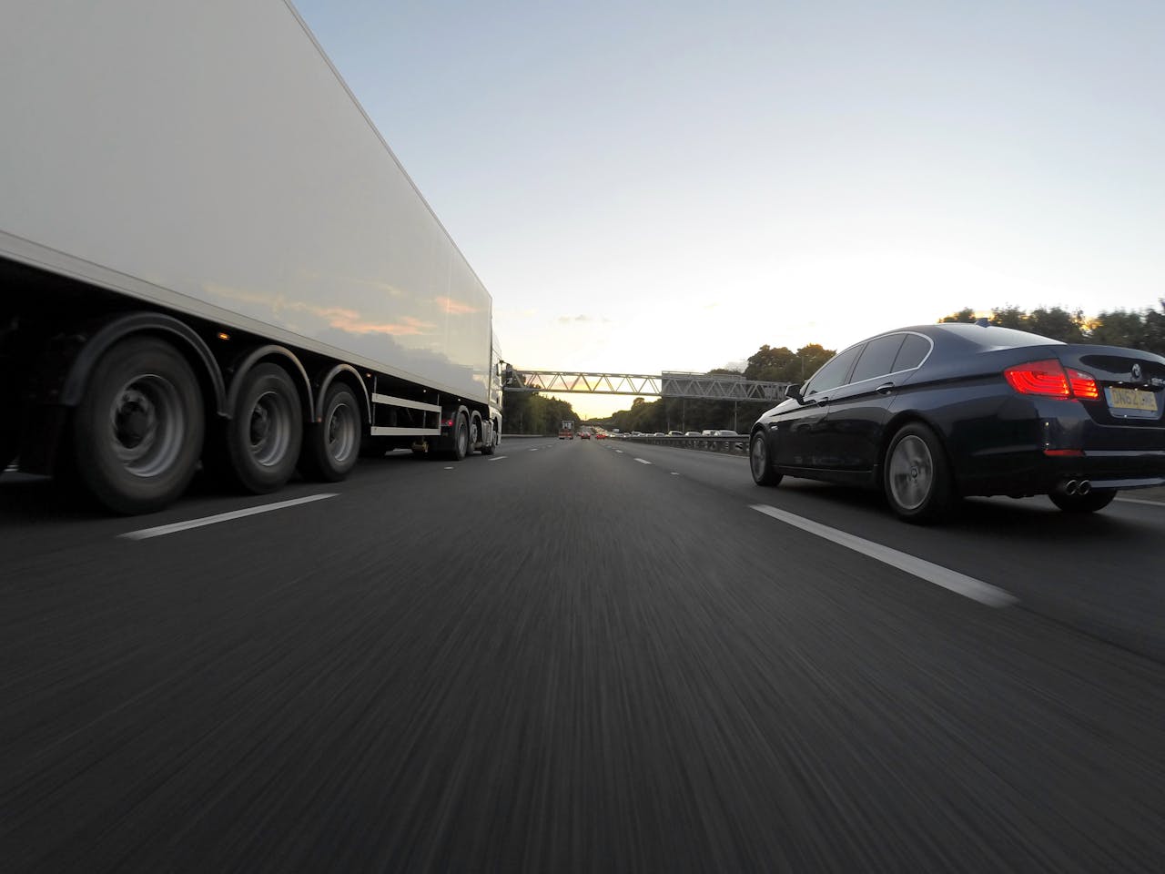 private-party-02 Cars and a truck speed along a highway under the clear sky, showcasing transportation dynamics.